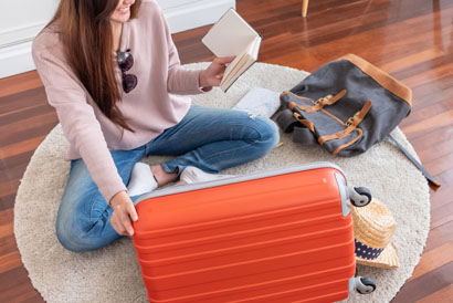 Young Asian Woman Traveler Prepare Things Into Orange Suitcase F