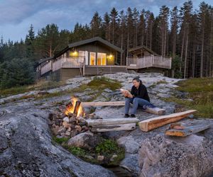 panoramic view woman reading near campfire in norway
