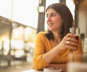 Woman in bar near to window drinking beverage